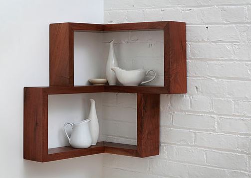 Two floating shelves mounted in the corner carrying white dish-ware.