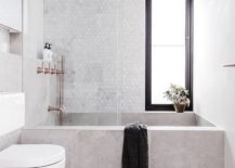 A bathroom featuring a marble-like tub and copper fixtures, creating a contrasting color scheme.