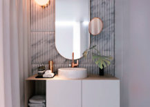 Marble bathroom with white sink and vanity accented by copper.