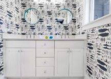 Blue and white contemporary boys' bathroom boasts a white dual washstand accented with anchor knobs and a light gray quartz countertop finished with polished nickel faucets fixed in front of a light gray quartz backsplash beneath two round aqua convex mirrors mounted to a wall clad in Swimming in The Sea Wallpaper.