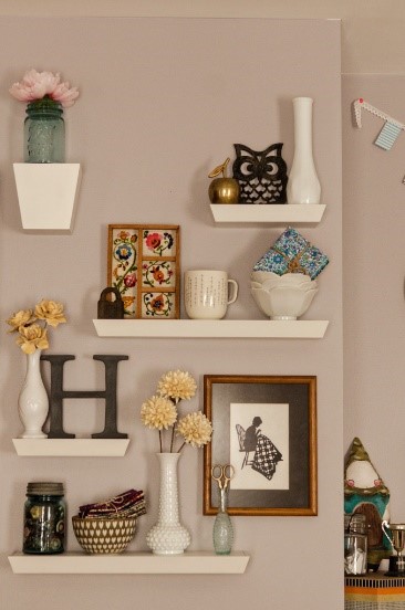 Four white floating shelves that come in two sizes showcasing vases, bowls, and a mason jar.
