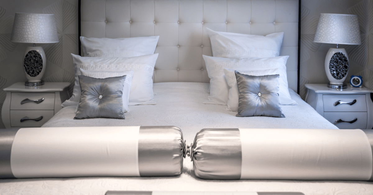 Bed with white and grey pillows.