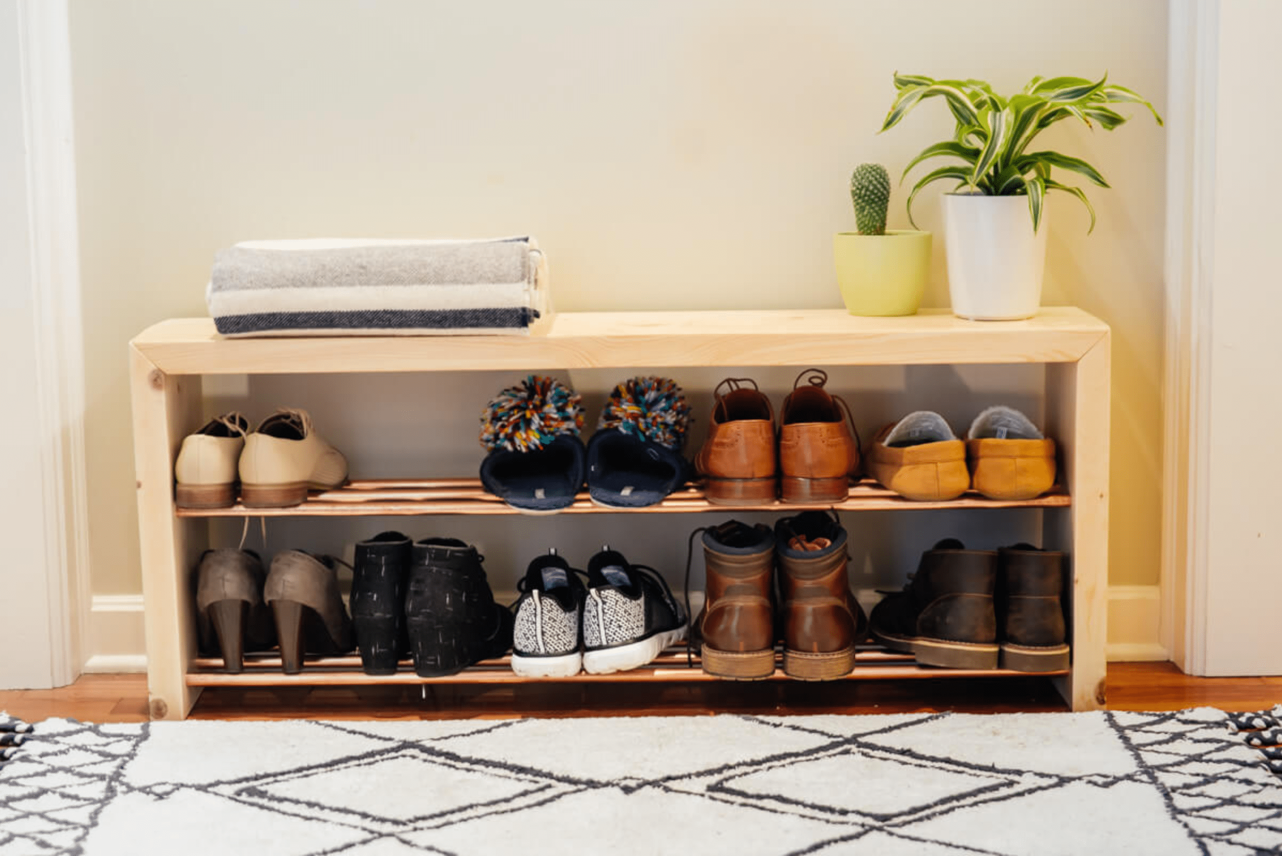 Wooden DIY shoe rack storing a collection of men and women shoes.