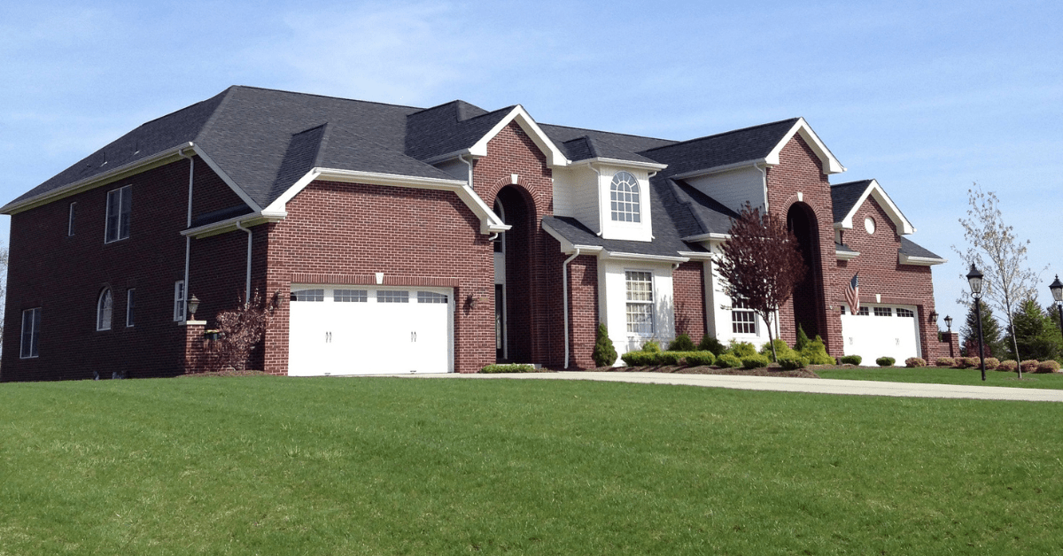 Luxurious and large duplex home with white door garages.
