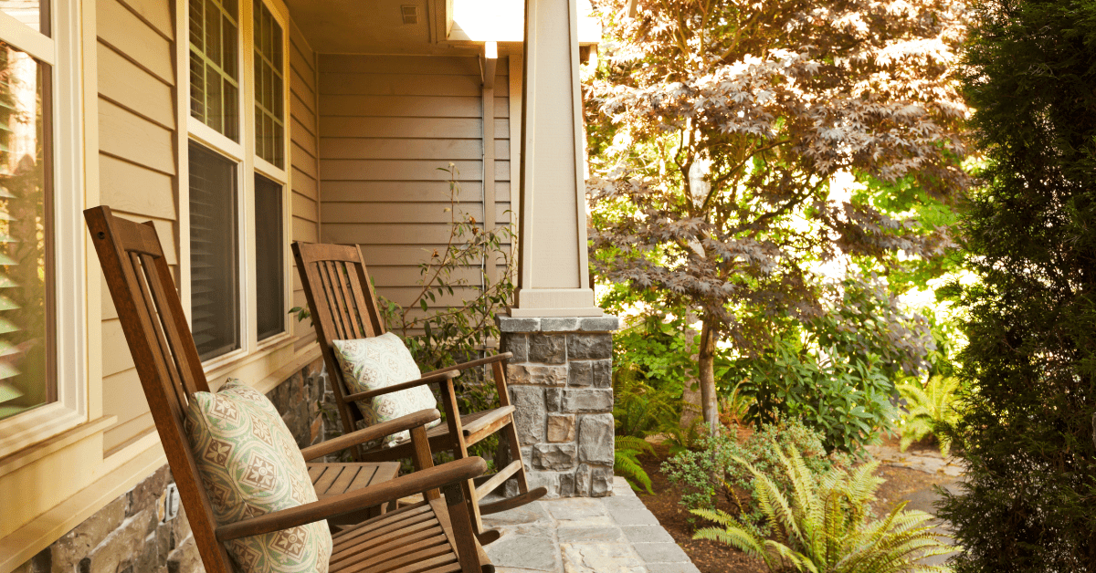 Front porch with furniture and. greenery.