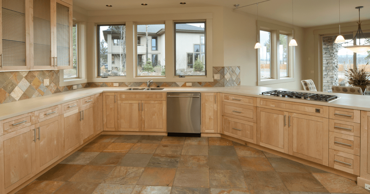 Wood cabinet kitchen with tile flooring.