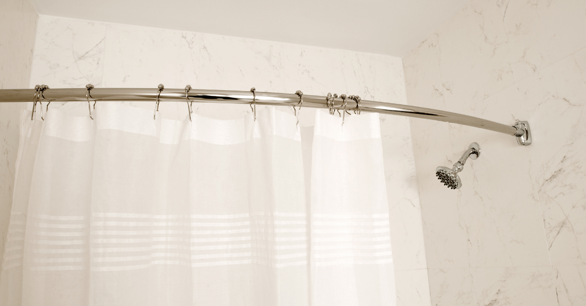 White standard shower curtain size hung on metal rod.