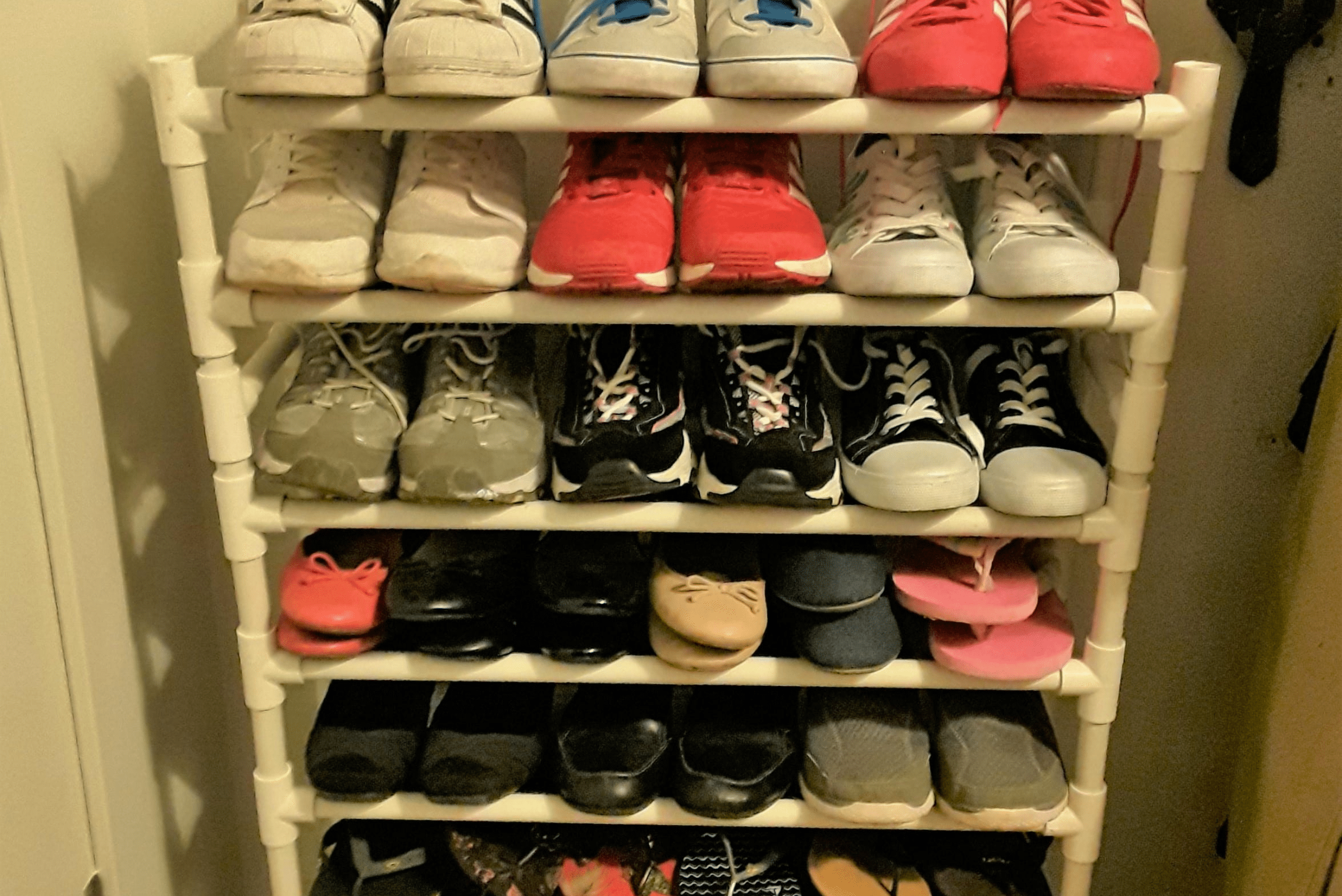 A DIY shoe rack made of PCV connectors and plastic pipes.