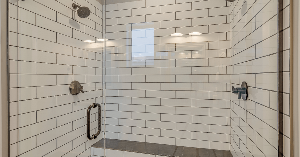 White subway tile shower with built-in sitting bench.