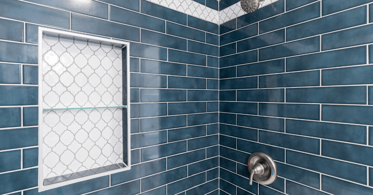 Blue subway tile shower with white patterned accent stripe.