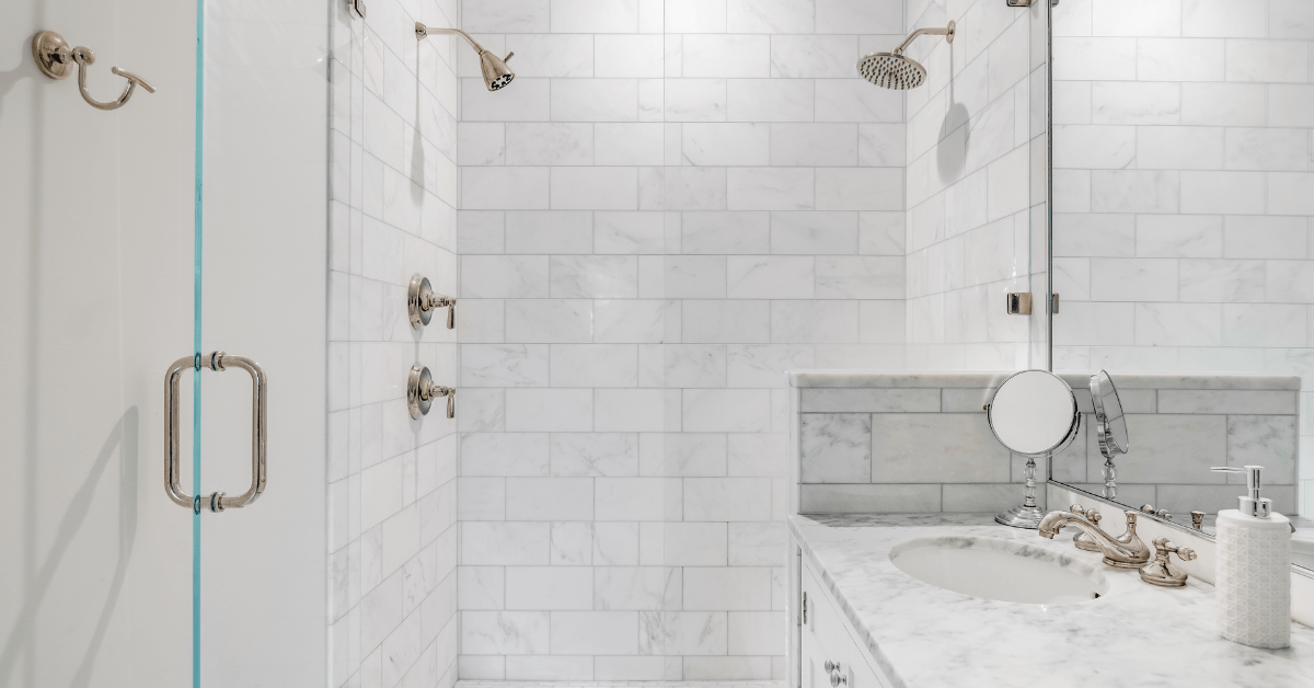 Marble white subway tile shower with metallic fixtures.