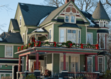 Victorian style house with large windows and green exterior walls.