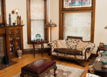 Living room of a Victorian style house with hard wood furniture and velvety upholstery.